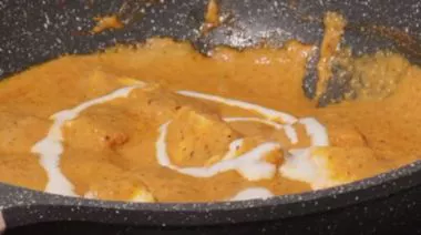 Shahi paneer in rich creamy gravy garnished with cream